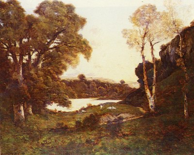 Goats grazing beside a lake at sunset
